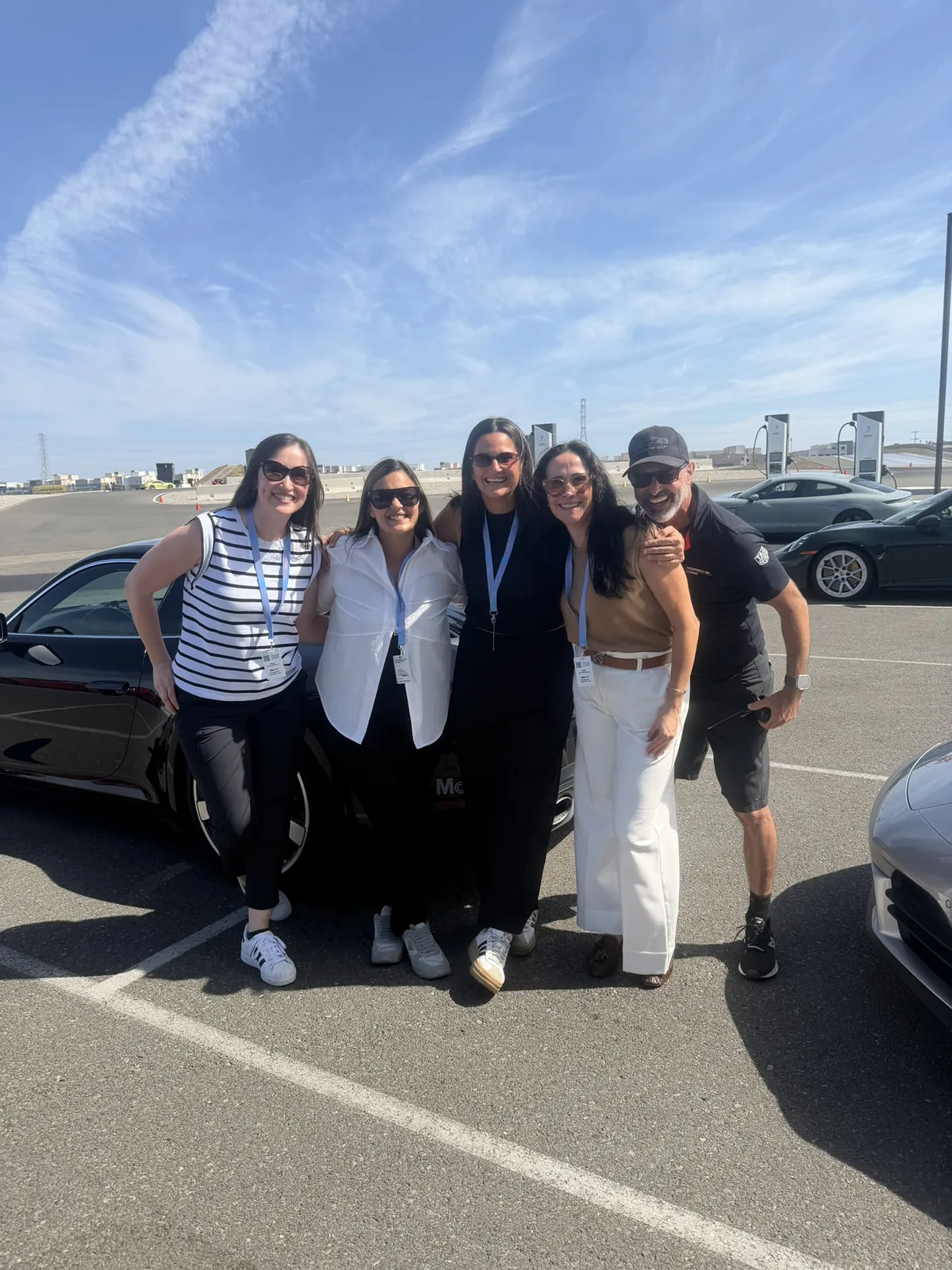 IGNITE 2026 attendees on the Porsche Experience Center grounds beside a Porsche